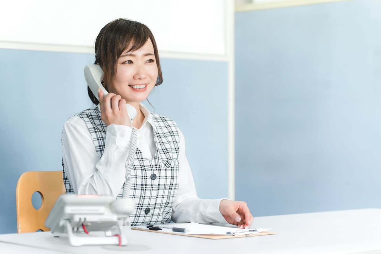 女性が笑顔で電話をしている様子