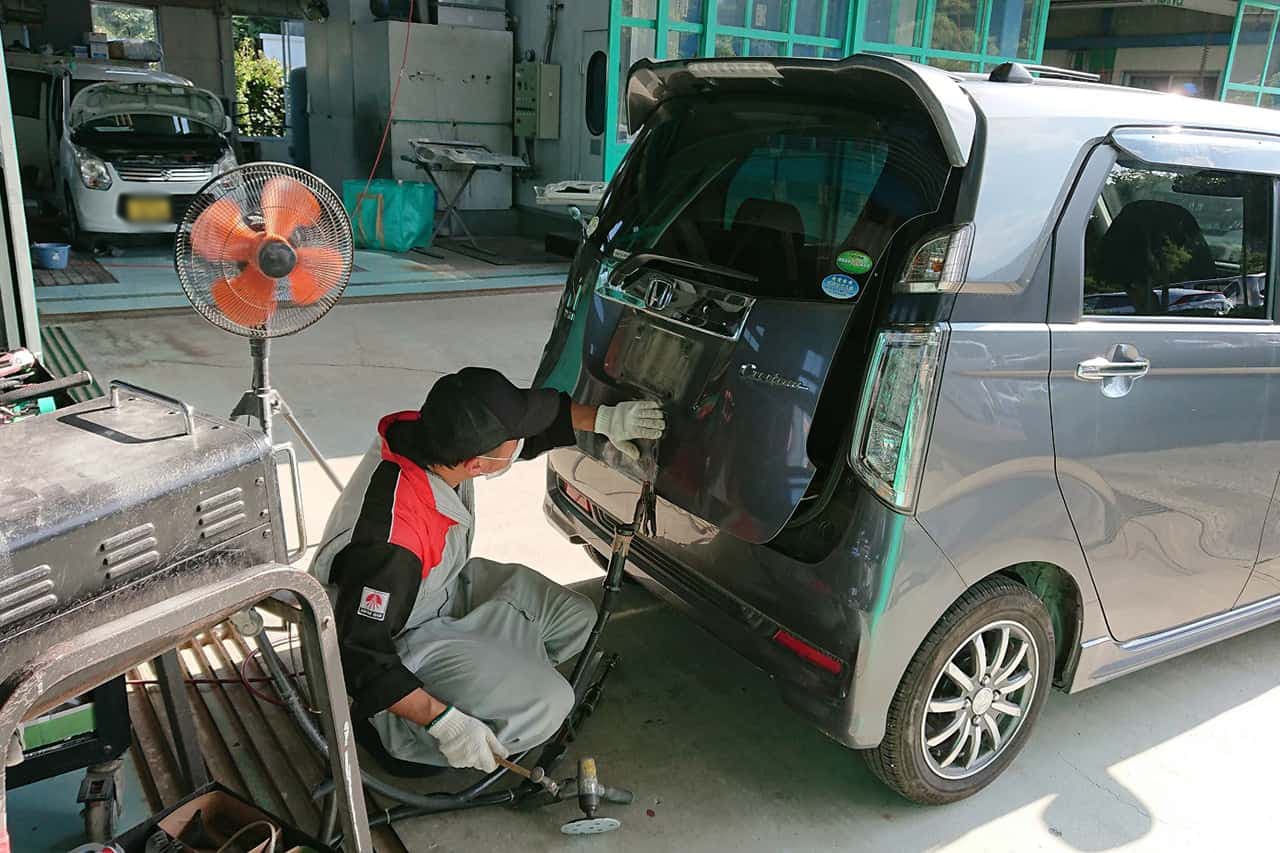 車の後部ドアのへこみを直しているところ